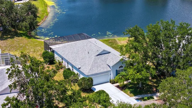 an aerial view of a house with a yard and large trees
