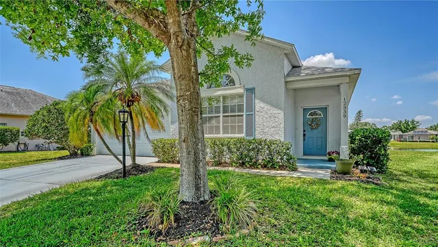 a view of a house with a yard and potted plants