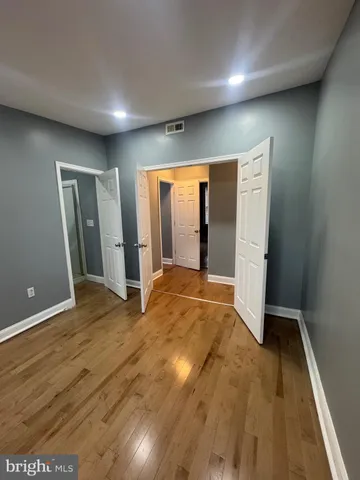 an empty room with wooden floor and closet