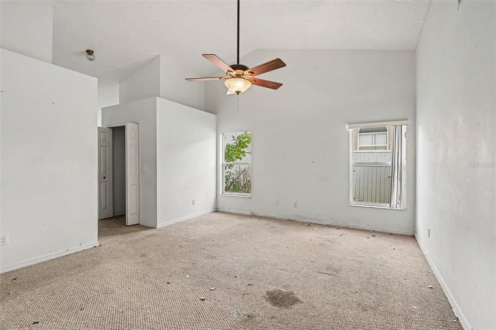 4716 Spaniel Street Orlando, FL 32818 - Photo 14 of 27 a view of an empty room with a ceiling fan and a window