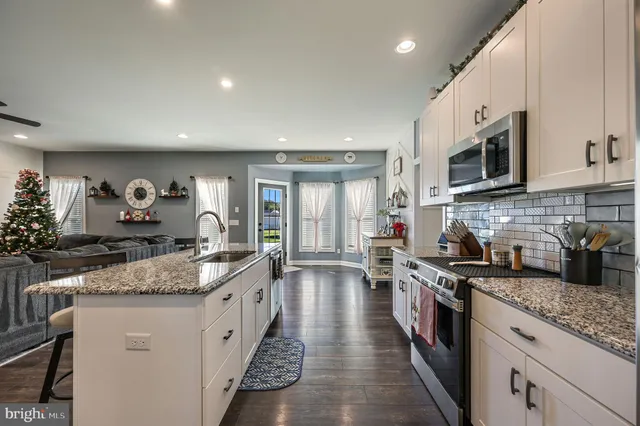 a large kitchen with stainless steel appliances granite countertop a lot of counter space and a sink