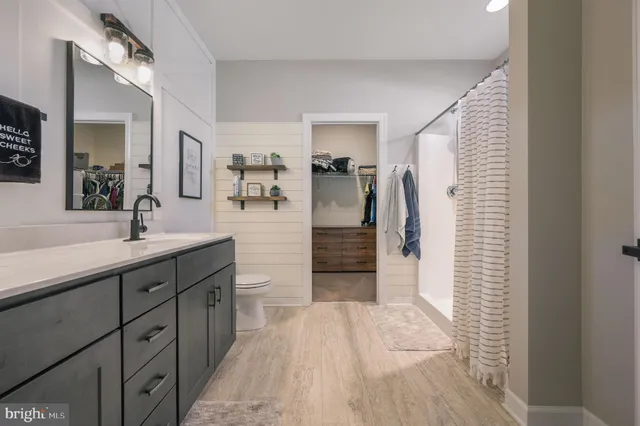 a spacious bathroom with a sink a mirror and shower