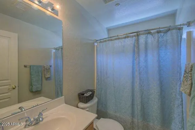 an empty room with wooden floor chandelier fan and windows