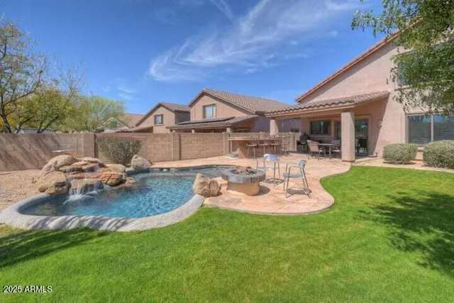 a view of a house with backyard and sitting area