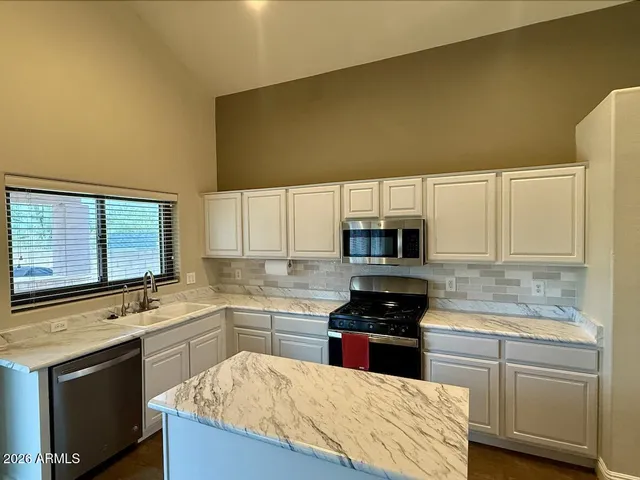 a kitchen with a sink stove top oven and cabinets
