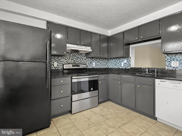 a kitchen with a stove a sink and a refrigerator