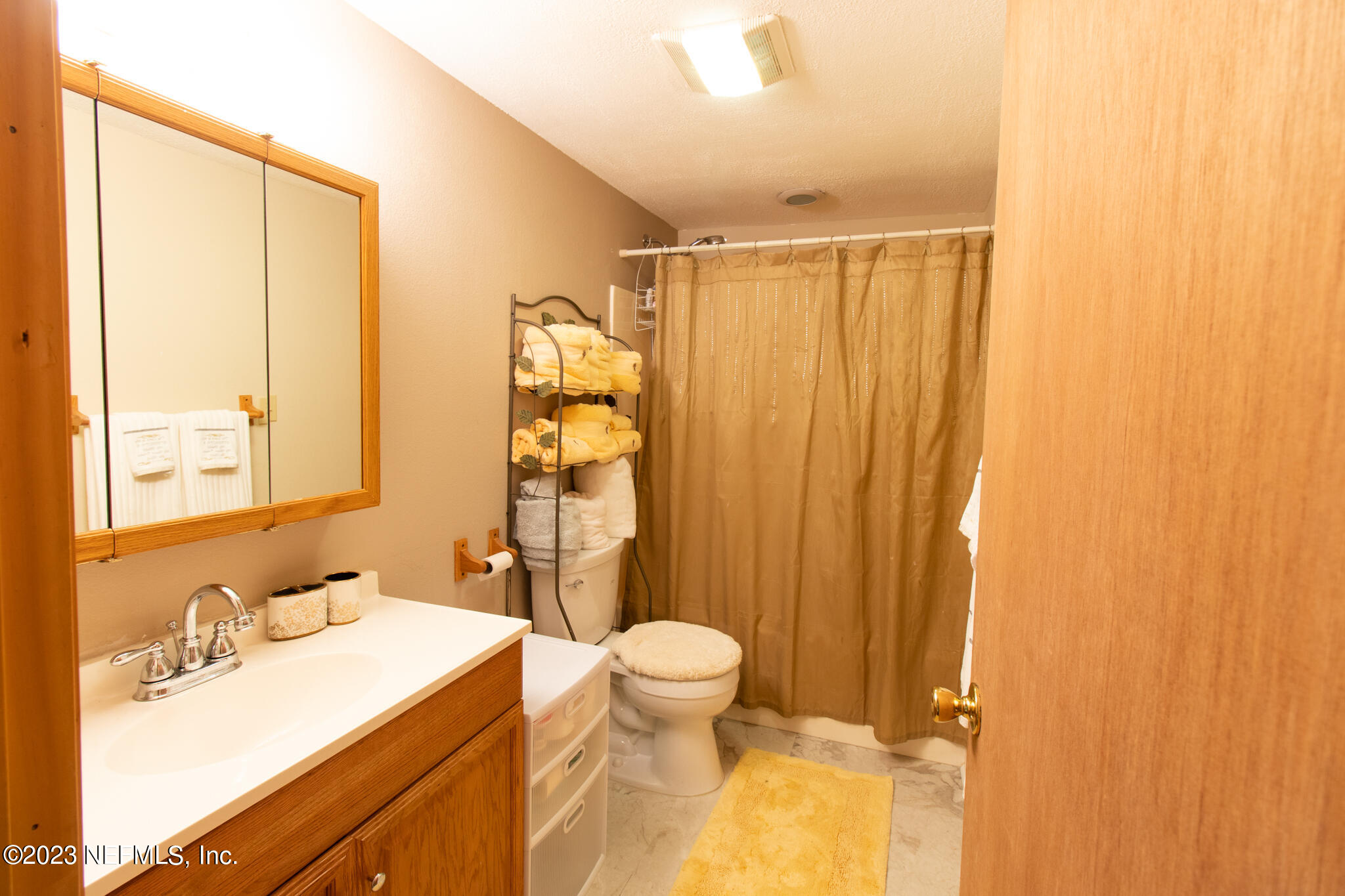 1151 Southeast 46th Loop Keystone Heights, FL 32656 - Photo 24 of 39 a bathroom with a sink a toilet and shower curtain