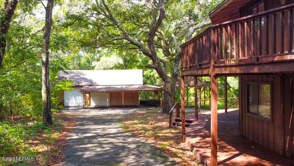 1151 Southeast 46th Loop Keystone Heights, FL 32656 - Photo 29 of 39 a view of a house with a large tree and wooden fence