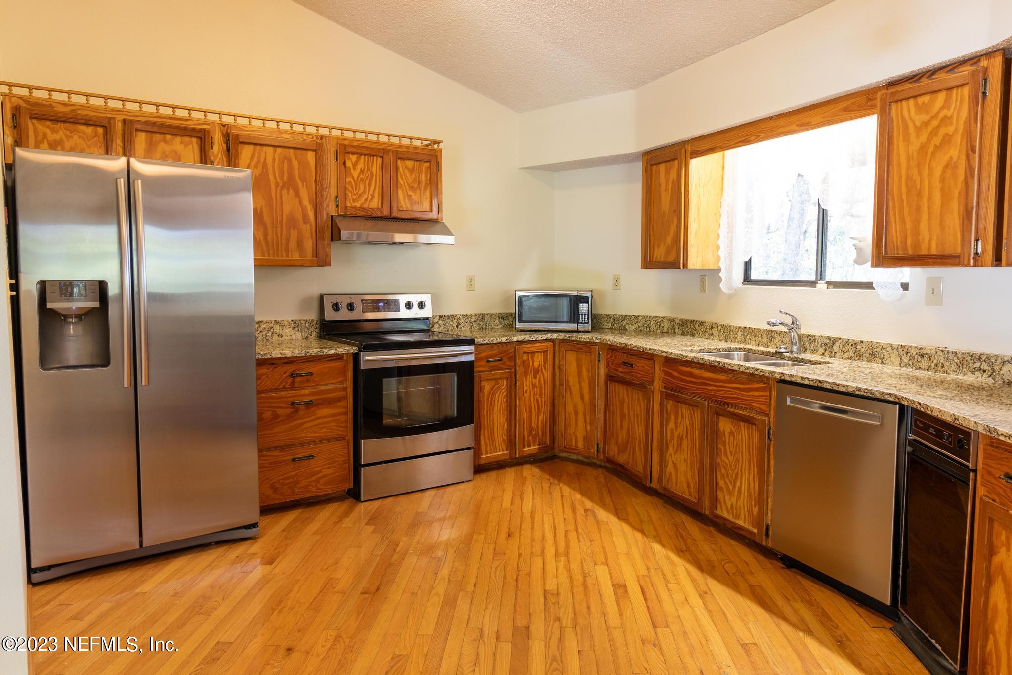 1151 Southeast 46th Loop Keystone Heights, FL 32656 - Photo 6 of 39 a kitchen with stainless steel appliances granite countertop a stove a sink dishwasher and a refrigerator