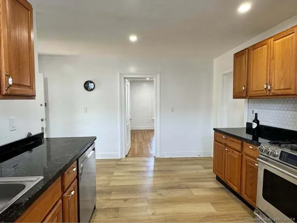 a kitchen with granite countertop a stove and a sink