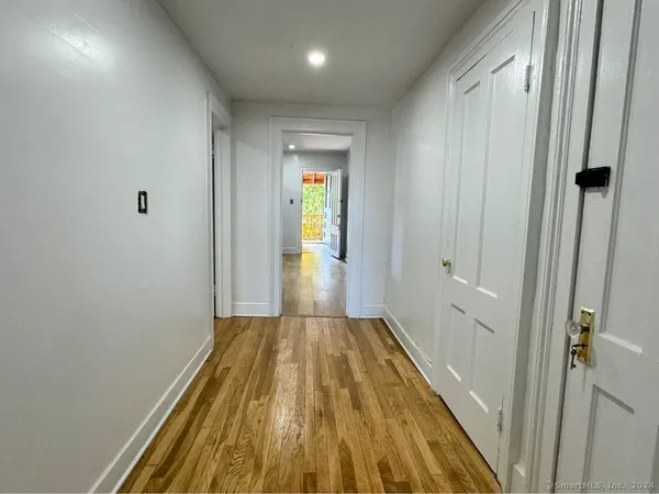 a view of a hallway with wooden floor