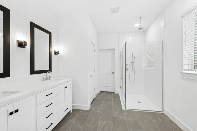 a bathroom with double vanity sink and mirror
