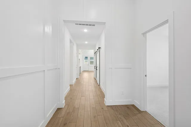 a view of a hallway with wooden floor