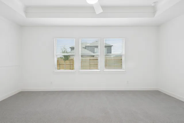 an empty room with a window and a ceiling fan
