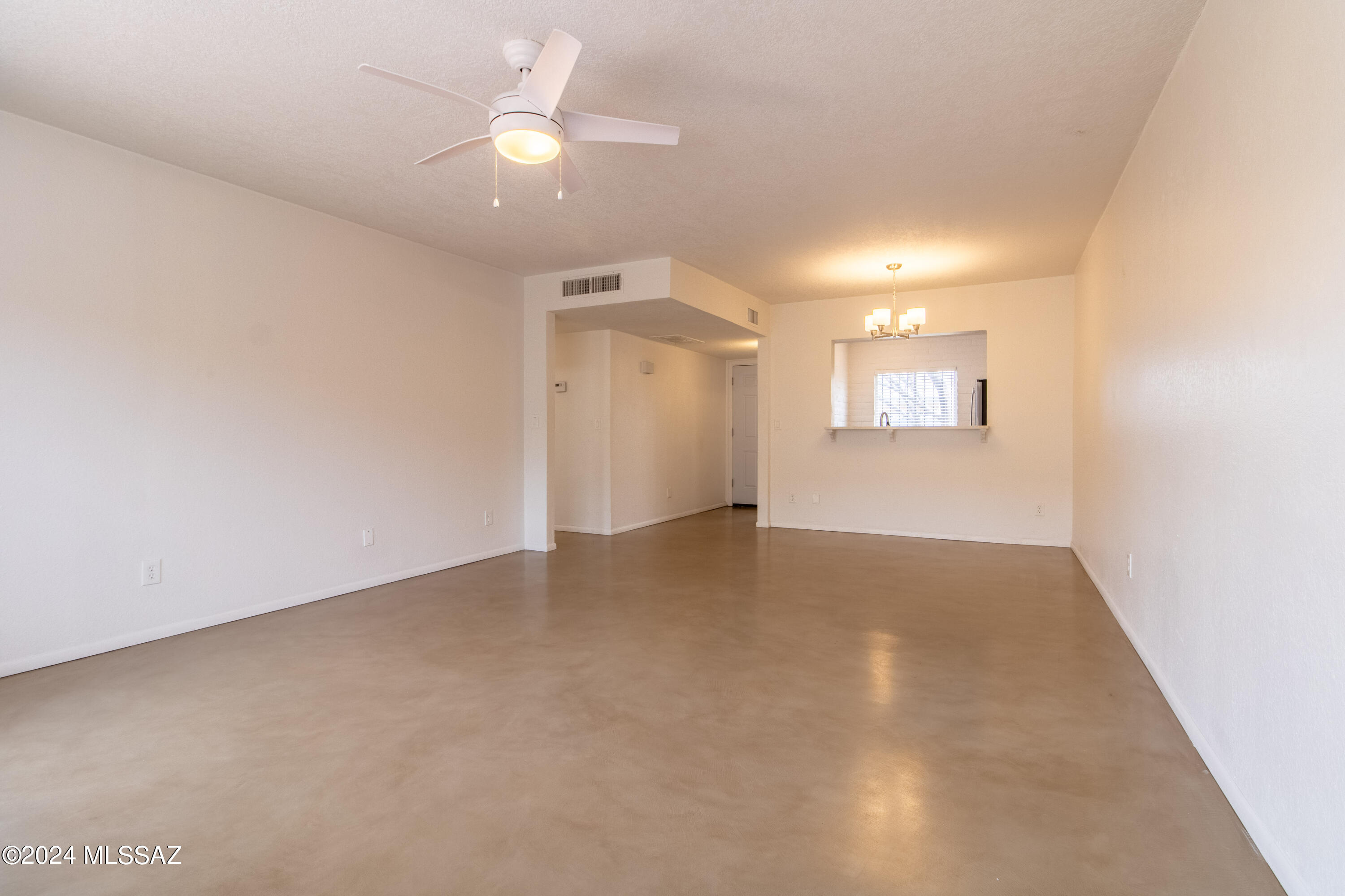 3552 South Mission Road, Unit B Tucson, AZ 85713 - Photo 7 of 21 an empty room with a ceiling fan and a window