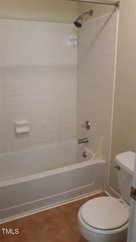 a white toilet and tub sitting next to a bath tub