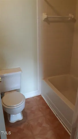 a bathroom with a toilet and a bath tub