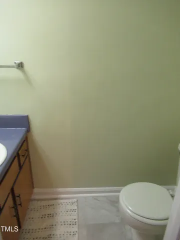 a white toilet sitting next to a shower