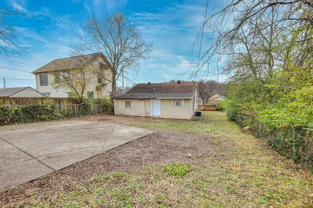 a view of a house with a yard and tree
