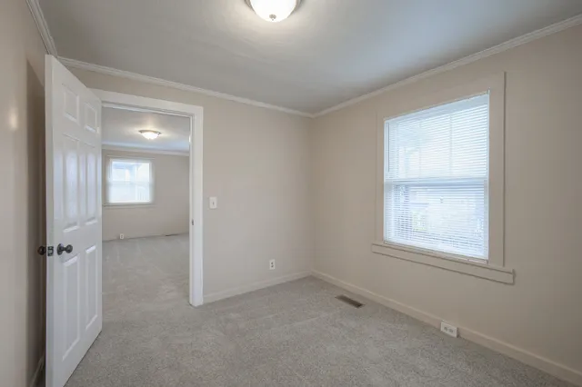 an empty room with windows and closet