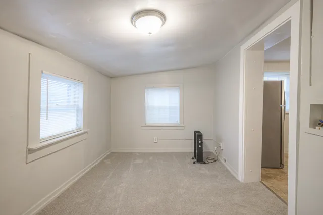 an empty room with windows and closet