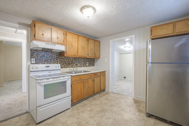 a kitchen with white cabinets and white appliances