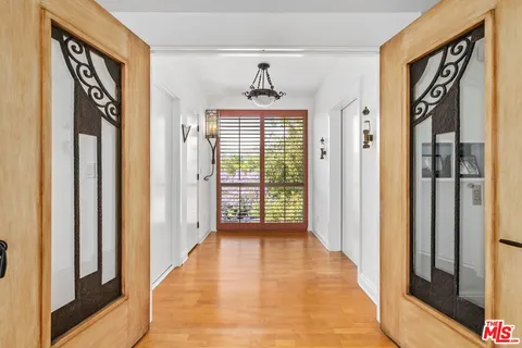a view of a hallway with wooden floor and windows