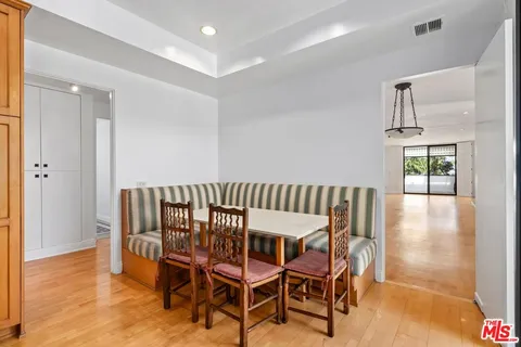 a view of a dining room and livingroom with furniture wooden floor a chandelier