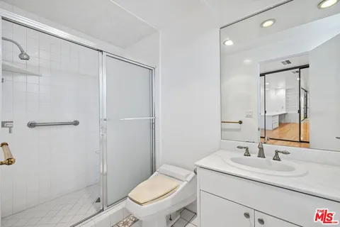 a bathroom with a granite countertop sink toilet and shower