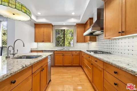 a large kitchen with granite countertop a sink and a stove