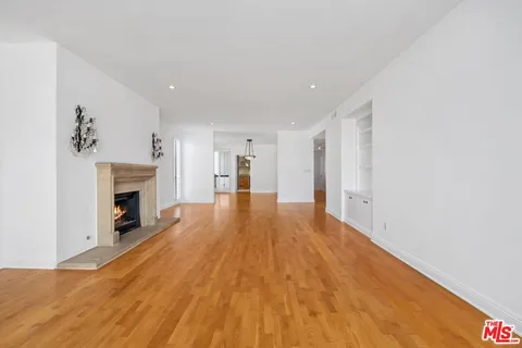 a view of a livingroom with wooden floor and a fireplace