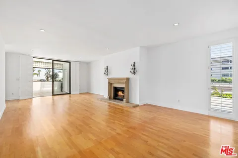 a view of an empty room with a window and fireplace