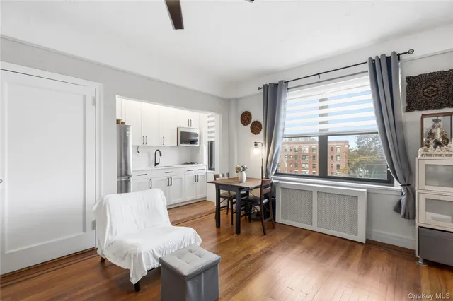 a room with stainless steel appliances a dining table chairs and a large window