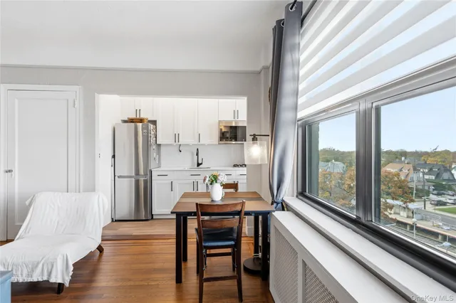 a kitchen with stainless steel appliances a dining table a stove a refrigerator and a window