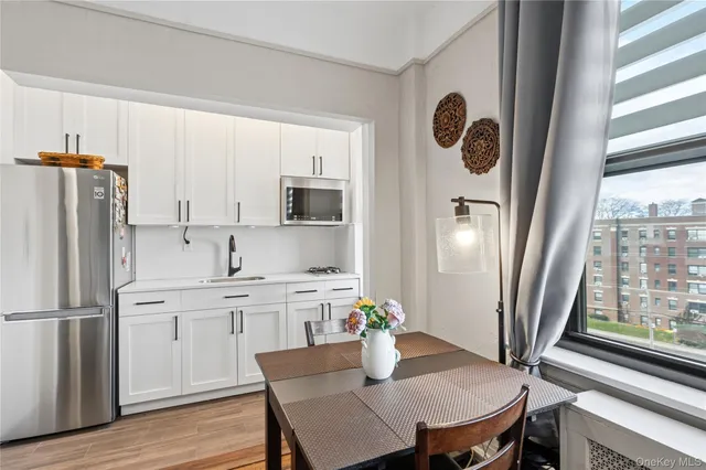 a kitchen with stainless steel appliances a refrigerator stove and white cabinets
