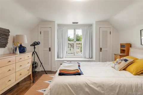 a bedroom with a bed a window and dresser