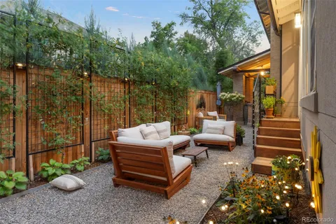 a view of a patio with couches table and chairs and potted plants