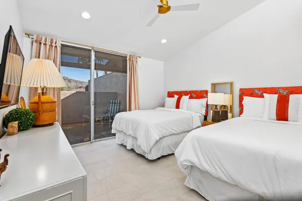 a bedroom with two beds and lamp