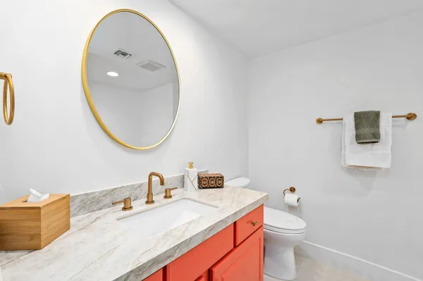 a bathroom with a granite countertop sink mirror and toilet