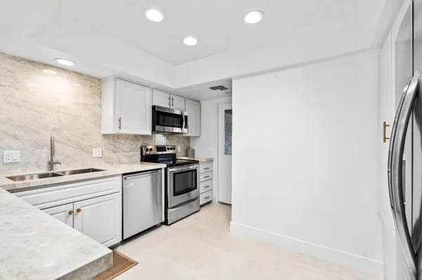 a kitchen with stainless steel appliances granite countertop a refrigerator sink and stove