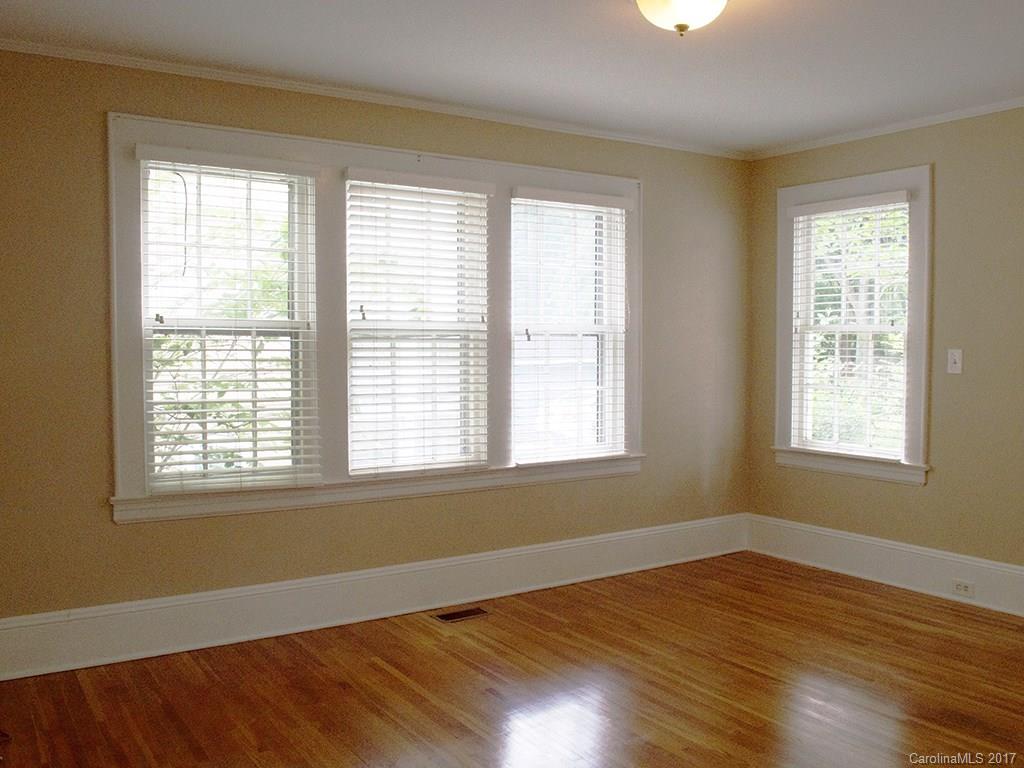 2304 Sharon Road Charlotte, NC 28207 - Photo 6 of 8 a view of an empty room with wooden floor and a window