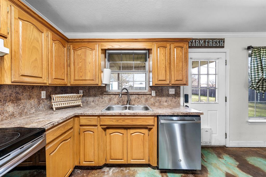 903 Amy Way Bonham, TX 75418 - Photo 11 of 27 Kitchen featuring stainless steel appliances, plenty of natural light, light countertops, wood finish cabinetry, and crown molding