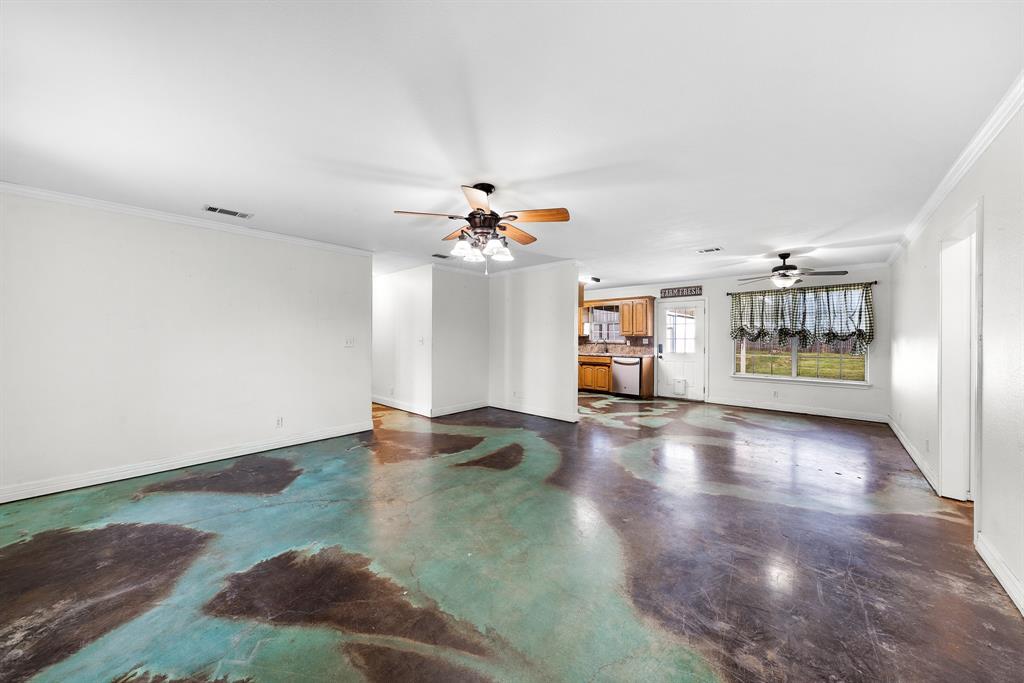 903 Amy Way Bonham, TX 75418 - Photo 14 of 27 Unfurnished living room featuring crown molding, finished concrete flooring, and ceiling fan