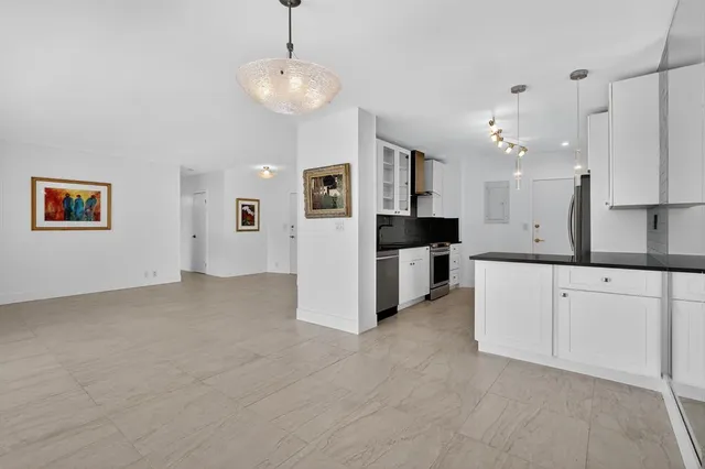 a large white kitchen with cabinets and stainless steel appliances