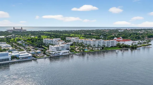 a front view of a building with garden and trees