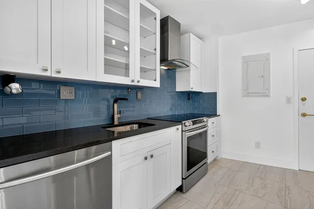 a kitchen with granite countertop white cabinets and white appliances
