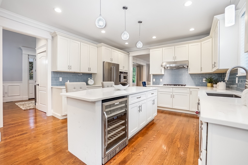 57 Walnut Street Newton, MA 02460 - Photo 19 of 39 a kitchen with kitchen island granite countertop a sink cabinets and wooden floor