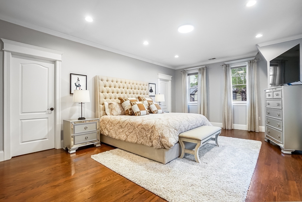 57 Walnut Street Newton, MA 02460 - Photo 25 of 39 a spacious bedroom with a large bed and a wooden floor