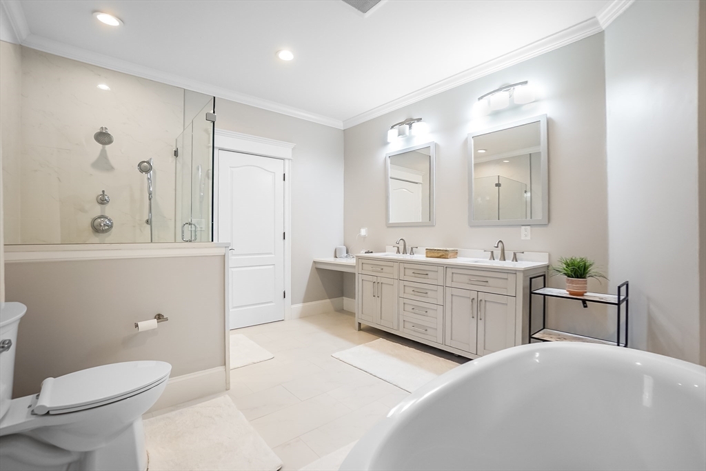 57 Walnut Street Newton, MA 02460 - Photo 27 of 39 a spacious bathroom with a double vanity sink a mirror a toilet and a bathtub
