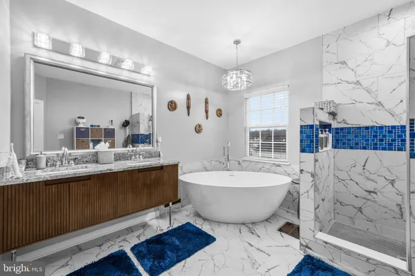 a spacious bathroom with a double vanity sink mirror and bathtub